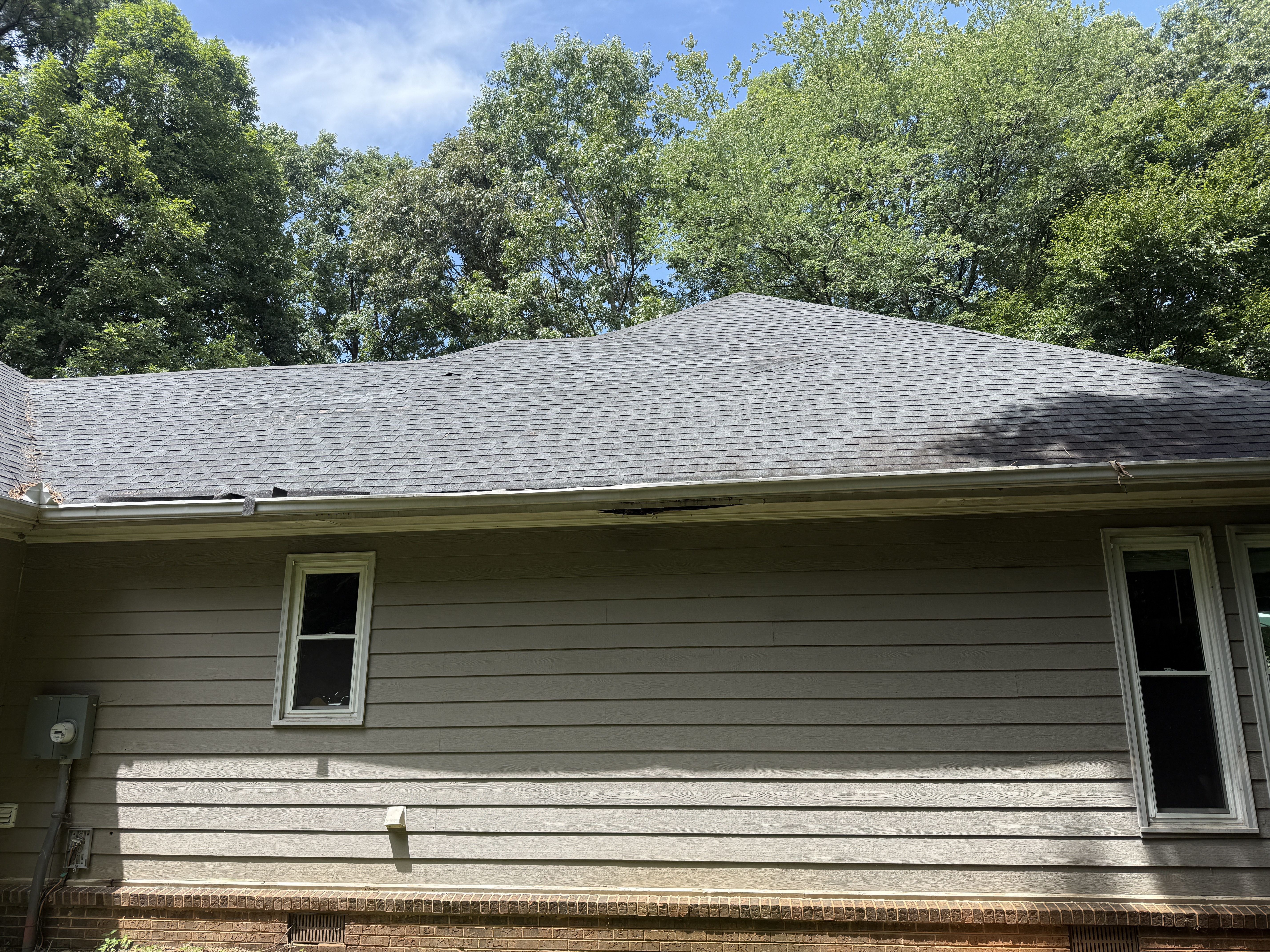 July 19, 2026. The roofline sags at mid-span and the fascia is rotting away at the eave.